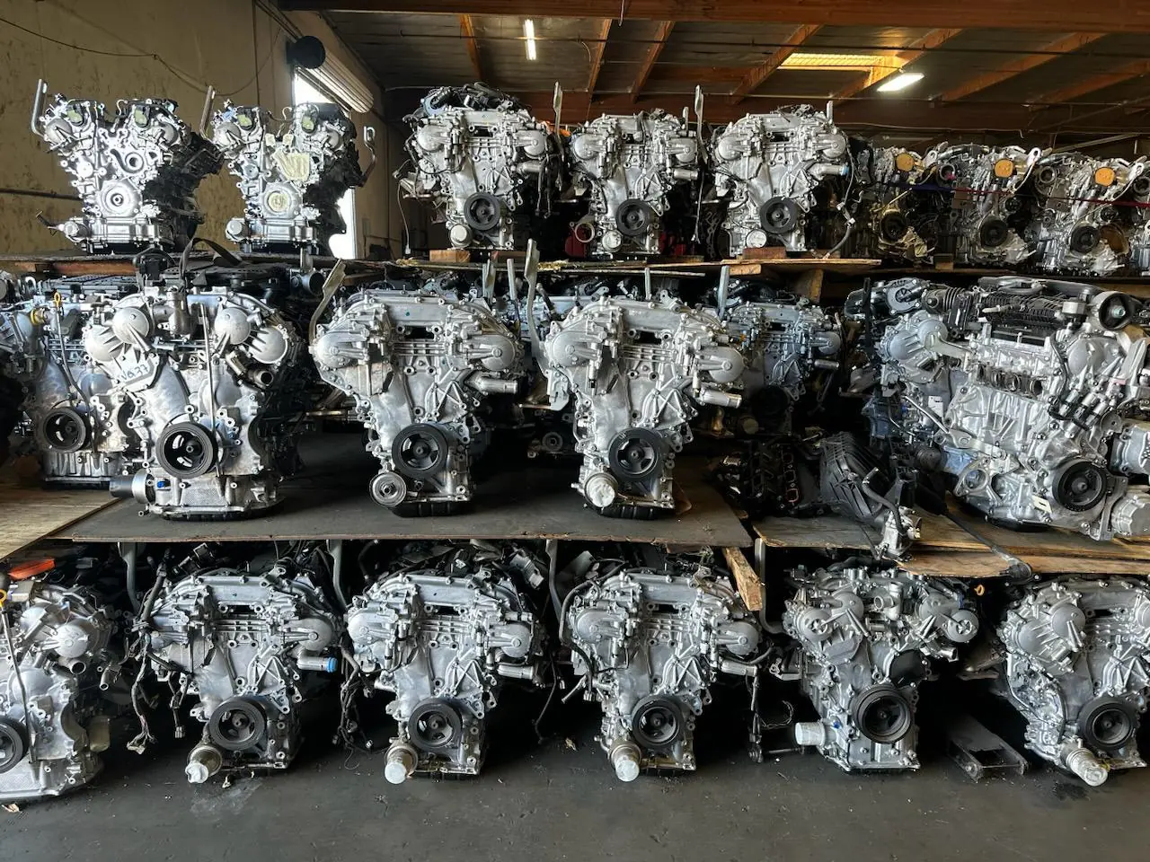 Rows of used automotive engines on steel shelving inside a warehouse